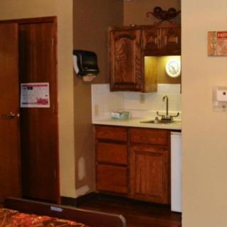 A cozy kitchenette in a hotel room featuring wooden cabinets and a small sink area.