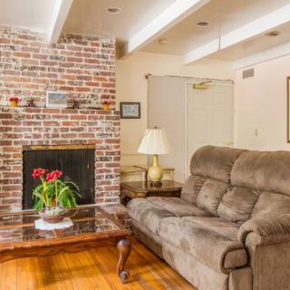 Cozy living room with a brick fireplace and comfortable seating.