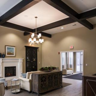 A modern living room featuring a fireplace, elegant chandelier, and comfortable seating area.