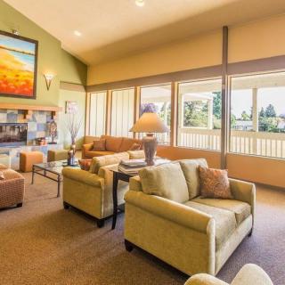 A spacious and well-lit living room with comfortable seating and large windows.