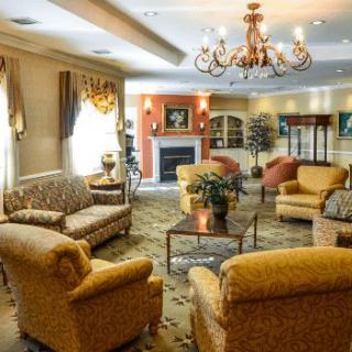 Elegant living room with a chandelier, comfortable seating, and a fireplace.