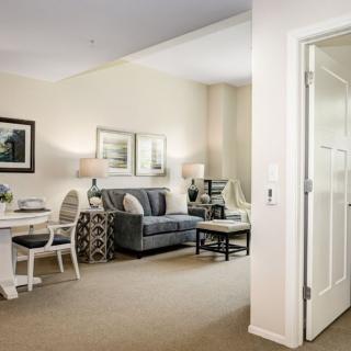 A cozy living room with an adjacent dining area, featuring stylish furniture and elegant decor.