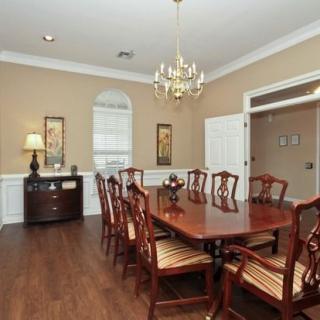 Elegant dining room with a large wooden table and chandelier.