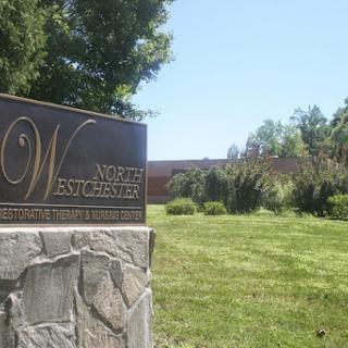 A bronze plaque sign marking a location amidst lush greenery.