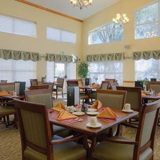 A well-lit dining area with neatly arranged tables and chairs.