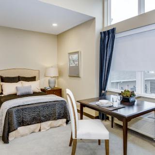 A cozy and modern bedroom featuring a comfortable bed and a stylish workspace by the window.