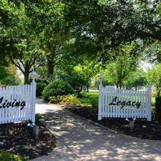 A peaceful pathway framed by lush greenery, inviting you to explore the Living Legacy.