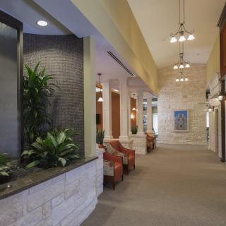 A spacious lobby with seating, plants, and decorative lighting.