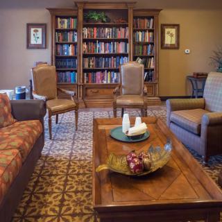 A cozy living room with bookshelves and comfortable seating arrangements.