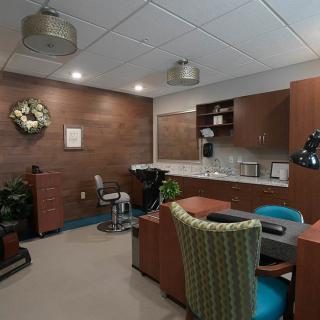 A modern office workspace with a desk, chairs, and cabinetry.
