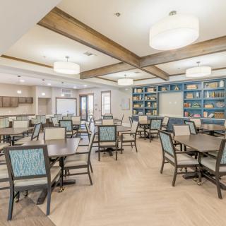 A well-lit dining area with neatly arranged tables and chairs, featuring modern decor.