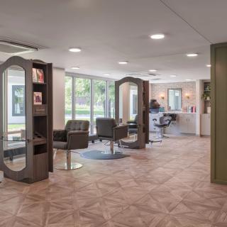 A modern salon with comfortable chairs and mirrors, featuring a stylish interior design.