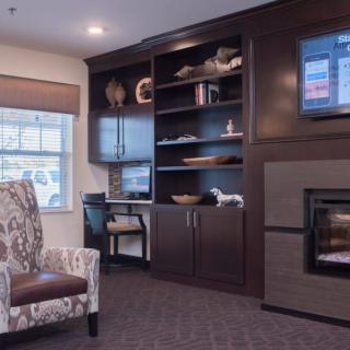 A cozy living room with a fireplace, television, and bookshelves.