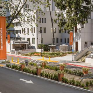 A hospital entrance with surrounding landscaping and parking area.