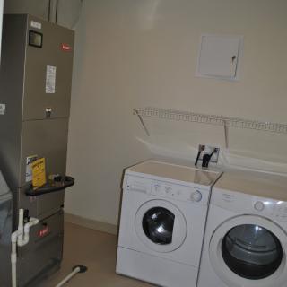A utility room featuring a washing machine, dryer, and water heater.