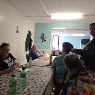 A casual gathering of people enjoying food and drinks indoors.