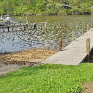A peaceful lakeside scene with a wooden dock extending into the water.