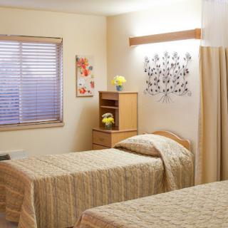 A neatly arranged bedroom with twin beds and simple decor.