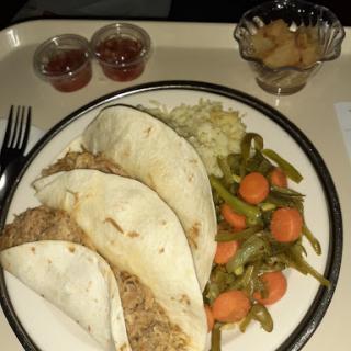 A hearty dinner featuring tacos, rice, and a side of mixed vegetables.