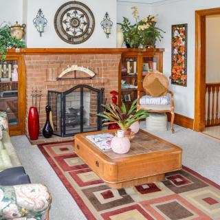 A cozy living room with a brick fireplace, stylish decor, and comfortable furniture.