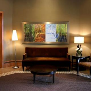 A cozy living room with a sofa, two lamps, and wall artwork.