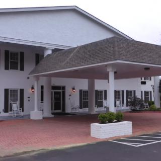 A building entrance with a covered walkway supported by columns.
