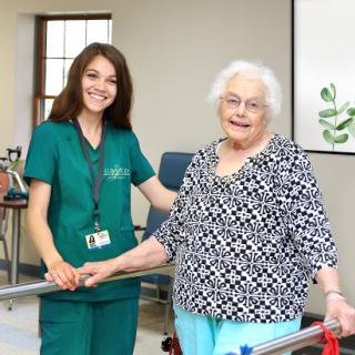 A nurse assisting an elderly patient during a rehabilitation session.