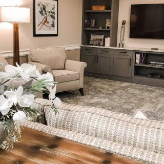 A cozy living room with comfortable seating, a large TV, and elegant decor.