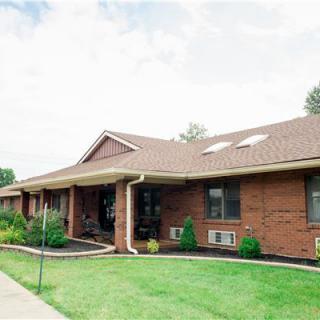 A residential brick house with a well-maintained lawn.