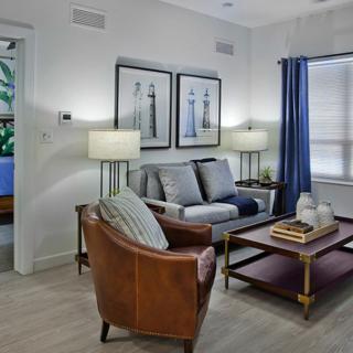 A cozy living room with a sofa, leather armchair, and stylish decor.