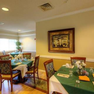 A cozy dining area with neatly arranged tables and chairs, featuring elegant decor.