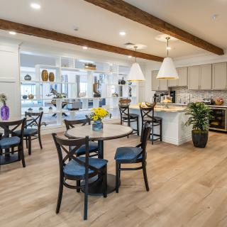 Modern kitchen and dining area with wooden beams and stylish lighting.