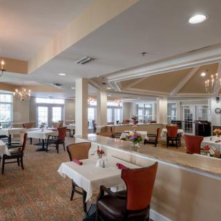 Spacious restaurant interior with elegant dining setup and chandeliers.