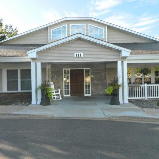 A front view of a building with a porch and white columns.