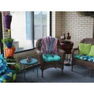 Cozy patio area with wicker chairs, colorful cushions, and decorative elements.