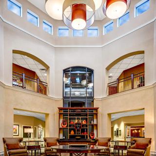 A modern lobby with high ceilings, elegant lighting, and comfortable seating areas.