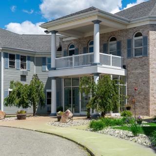 A modern house with a grand entrance and landscaped surroundings.