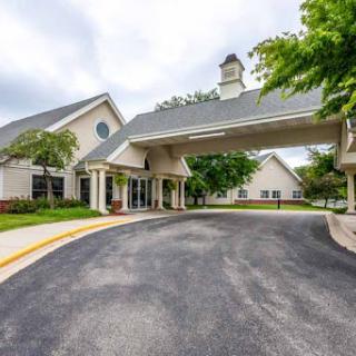 A welcoming entrance to a well-designed building, surrounded by greenery.