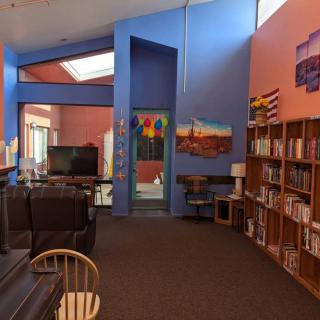 A cozy library reading area with colorful walls and bookshelves filled with books.