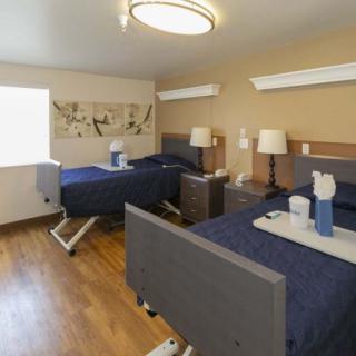 A modern room with two neatly made beds, featuring stylish decor and warm lighting.