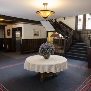 A welcoming lobby featuring a decorative table with flowers and an elegant staircase.