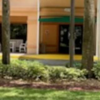 A building entrance surrounded by lush greenery and trees.