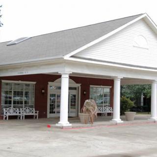 A brick building with a covered entrance supported by columns.
