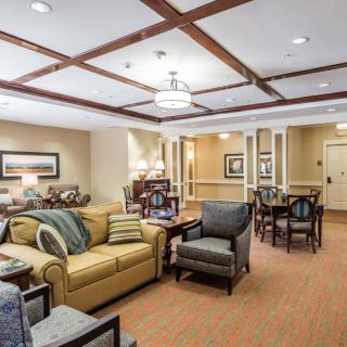 A cozy and elegantly designed living room with comfortable sofas, armchairs, and warm lighting.