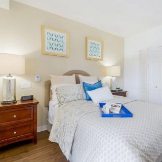 A cozy bedroom with a neatly made bed, bedside tables, and soft lighting.