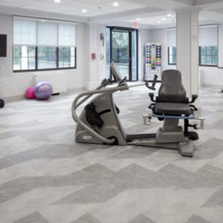 A modern gym space featuring a variety of fitness equipment and bright lighting.