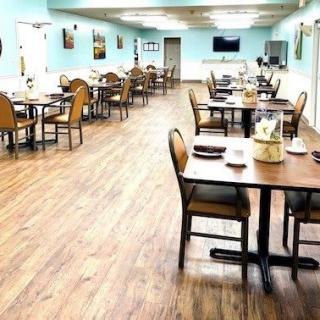 A spacious and empty dining area with neatly arranged tables and chairs.