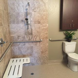 Accessible bathroom with a shower bench and safety grab bars.