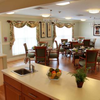 A cozy dining area with a kitchen counter, featuring elegant decor and ample natural light.
