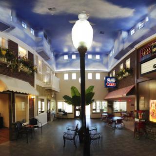 A charming indoor atrium designed to resemble an outdoor plaza, complete with a streetlamp and seating area.